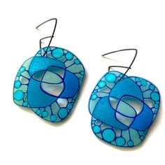 two blue earrings with circular designs on them