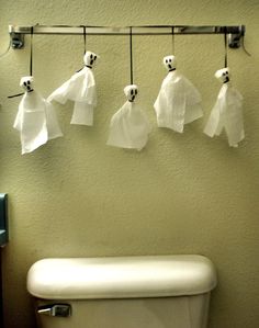 several white towels hanging on the wall above a toilet