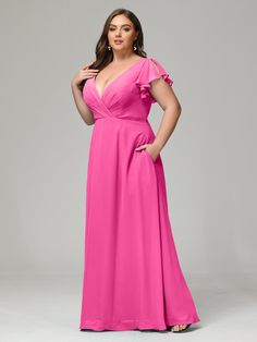 a woman in a pink dress posing for the camera with her hands on her hips