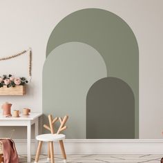 a living room with a wall painted in shades of green and grey, including an arch