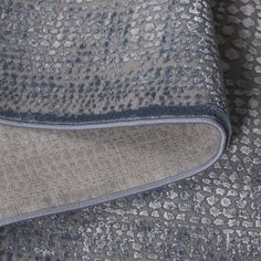 an up close shot of a gray and blue fabric with small dots on the side