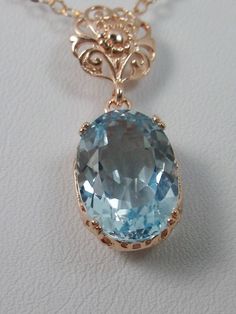 Natural Topaz Pendant Necklace, blue topaz pendant, with a natural blue topaz oval stone set in floral rose gold filigree, 4 prongs hold the gem in place, Silver Embrace Jewelry Elegant Oval Topaz Necklace, Elegant Oval Blue Topaz Necklace, Elegant Oval Pendant Topaz Jewelry, Fine Jewelry In Rose Gold With Blue Topaz, Elegant Blue Topaz Necklaces, Elegant Formal Topaz Necklaces, Elegant Topaz Oval Pendant Necklaces, Elegant Topaz Oval Pendant Necklace, Elegant Oval Pendant Topaz Necklace