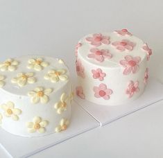 two white cakes with pink and yellow flowers on them