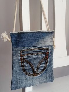 a purse made out of jeans hanging on a chair