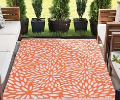 an orange and white area rug on top of a wooden bench next to potted plants