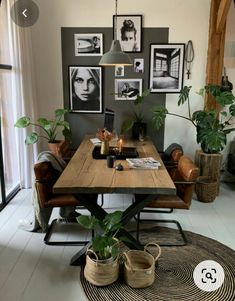 a table with some plants and pictures on the wall