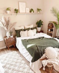 a bedroom with white and green decor on the walls, bedding, rugs and plants