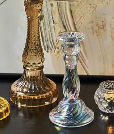 three glass candlesticks sitting next to each other on a table