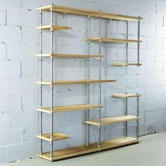 an empty shelf in front of a white brick wall with shelves on each side and metal bars at the bottom