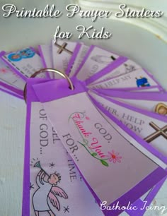 purple paper states for kids with cross and name tags on them sitting in a white bowl