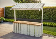 a wooden bench sitting in front of a white gazebo on top of a hard wood floor