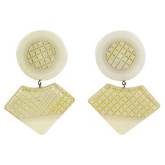 These lovely Lucite or resin clip-on earrings feature geometric dangling elements in the cream-off-white color background with a geometric gilt-embedded design. There is no visible designer's mark. Measurements: 1.94 in wide (4.9 cm) x 2.75 in high (7 cm). Vintage White Drop Clip-on Earrings, White Retro Formal Earrings, Retro White Clip-on Jewelry, Retro White Dangle Earrings, White Retro Earrings For Formal Occasions, Retro White Earrings For Formal Occasions, Chic White Dangle Clip-on Earrings, Chic White Clip-on Earrings For Formal Occasions, Colorless Diamond