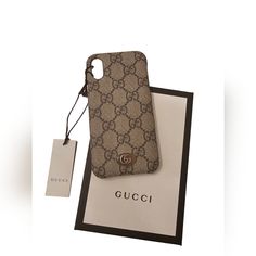 a gucci phone case sitting on top of a white box next to a tag