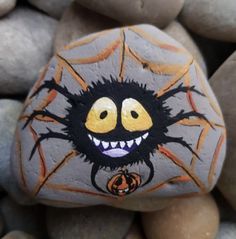 a painted rock with an image of a spider on it's face and smiling eyes