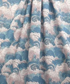 a blue and pink wave print curtain with white swirls on the bottom half of it