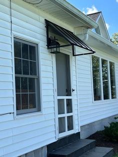 a white house with an awning on the front porch