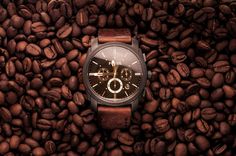 a watch sitting on top of a pile of coffee beans