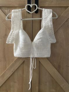 Discover timeless elegance with our white handmade crochet crop top! 🌟 Expertly crafted with intricate crochet patterns, this top offers a unique blend of sophistication and comfort. The delicate white yarn creates a fresh, airy look that's perfect for any occasion, from a summer day out to a chic evening event. Its breathable fabric and flattering fit ensure you stay stylish and comfortable all day long. Embrace the charm of hand-made craftsmanship and make a statement with this must-have ward White Fitted Crochet Top For Vacation, Fitted White Crochet Top For Festivals, White Fitted Crochet Top For Festivals, White Fitted Crochet Top For Festival, White Crochet Crop Top For Festival, Fitted Crochet Lace Top For Vacation, White Cropped Crochet Top For Festival, Handmade Lace Crochet Top For Summer, White Crochet Lace Top For Summer