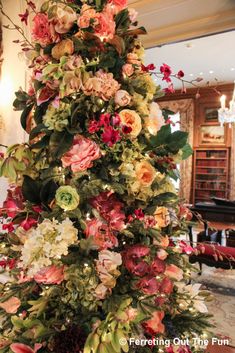 a christmas tree decorated with flowers and greenery