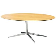 an oval wooden table with metal legs and a circular top, viewed from the front