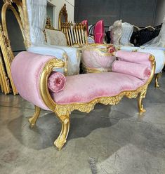 two pink and gold couches sitting next to each other in front of a mirror