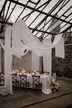 an outdoor dining area with sheer curtains and candles