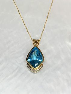 An elegant handmade Blue Topaz pendant with bezel setting and exceptional detailing. Featuring a vibrant multi faceted 27.46 carat center stone, accented by 0.25 carats of white diamonds set in solid 18k yellow gold. *Please note this is part of our luxury 18k gold collection, the pendant has been custom made for this stone. Blue Topaz Necklaces With Accent Stones, Sapphire Topaz Necklace With Accent Stones, Blue Topaz Necklace With Accent Stones, Blue Topaz Necklaces With Diamond Accents, Topaz Gemstone Pendant Jewelry, Fine Jewelry Blue Topaz Pendant, Yellow Gold Blue Topaz Pendant Jewelry, Blue Topaz Pendant Necklace With Gemstone Accents, Blue Gem Necklace