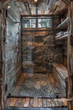 the inside of a wooden cabin with stone flooring and walls, along with a walk - in shower