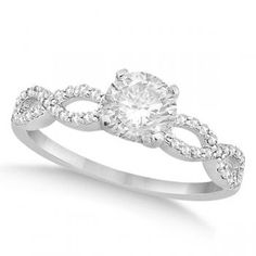 a white gold ring with an oval diamond center surrounded by round brilliant czrs