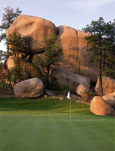 a golf course with large rocks and trees