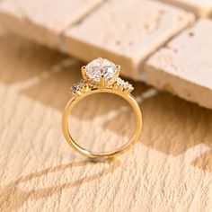 a diamond ring sitting on top of a piece of paper next to a brick wall