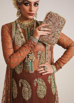 Pakistani Wedding Dress in Brown Sharara and Gown Style is a stunning attire embellished with Naqshi, Dabka, Sequins, Motifs, and Cut-dana. Fast shipping. Traditional Hand Embellished Formal Lehenga, Traditional Hand Embellished Lehenga For Formal Occasions, Traditional Formal Gown With Intricate Embroidery, Elegant Hand Embellished Wedding Dress With Traditional Drape, Elegant Wedding Dress For Reception, Elegant Formal Gown With Dabka Work, Elegant Festive Gown For Ceremonies, Luxury Organza Wedding Gown, Elegant Wedding Dress With Traditional Drape