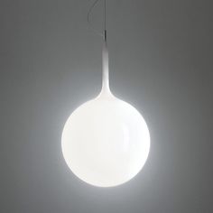 a white light hanging from the ceiling in a room with grey walls and flooring