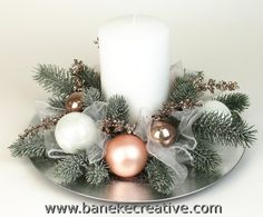 a white candle is sitting on a plate with christmas decorations and greenery around it