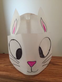 a paper plate with a cat's face painted on the side and ears cut out