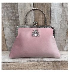 Stunning, handmade, blush pink velvet purse bag with bee detail. The lining is made with a beautiful cotton fabric. Use it as a classic clutch or attach the shoulder strap to wear over your shoulder or as a crossbody. - Silver colour Chain strap (detachable) - Silver colour Metal Top handle ( not detachable) - H:19cm x W:29cm x D:4cm approximately - Metal clasp: H:6.5cm x W:20cm - Top handle: H:8.5cm The pattern of the lining inside of the bag may vary. But don't worry, I always make sure the li Blush Rectangular Bag For Parties, Blush Rectangular Party Bag, Rectangular Blush Party Bag, Feminine Pink Clutch Evening Bag, Elegant Rectangular Blush Clutch, Elegant Blush Rectangular Clutch, Vintage Pink Clutch For Formal Occasions, Pink Rectangular Vintage Evening Bag, Elegant Pink Pouch Coin Purse