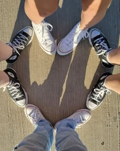 four people standing in a circle with their legs crossed