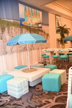 an indoor seating area with blue and white chairs, tables and umbrellas on the wall