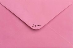 an open pink envelope with the word love written on it