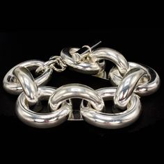 This fabulous sterling silver link bracelet was made in Taxco, Mexico. It contains 9 oversize oval links that measure 1.3" x 1.18". Every second link—the ones that lift off the wrist—has a flat bottom, making it silk as smooth to wear! Metal: Sterling Silver Length: 9" Weight: 2.09 oz Silver Chunky Chain Bracelet For Formal Occasions, Chunky Oval Link Silver Chain Bracelet, Silver Chunky Oval Link Chain Bracelet, Modern Chunky Oval Link Bracelets, Silver Chunky Classic Jewelry, Classic Silver Chunky Jewelry, Classic Chunky Silver Jewelry, Sterling Silver Oval Link Bracelet With Polished Finish, Elegant Chunky Oval Link Bracelets