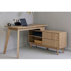 a wooden desk with a laptop on top of it next to a lamp and bookshelf