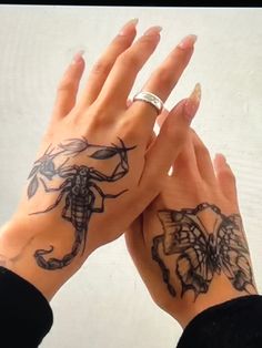 two hands holding each other with tattoos on them