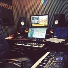 a recording studio with an electronic keyboard, monitor and sound board in front of it