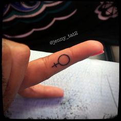 a person's finger with a small tattoo on it