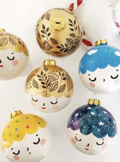 five christmas ornaments with faces painted on them