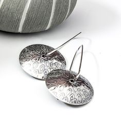 Handmade Silver Textured Dangle Earrings These fun dangle earrings are made with sterling silver and have a cool petal design on the domed discs.  The earrings have been given a patina to enhance the petal texture and create an organic style.  The earrings are approximately 1 3/4 inches long and the textured discs are Silver Etched Round Earrings, Etched Sterling Silver Dangle Earrings, Etched Metal Drop Earrings, Modern Sterling Silver Round Disc Earrings, Art Jewelry Earrings, Silver Earrings Handmade, Organic Style, Lovely Earrings, Jewellery Ideas