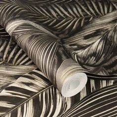 a black and white wallpaper with palm leaves on the back ground, as well as a roll of tape