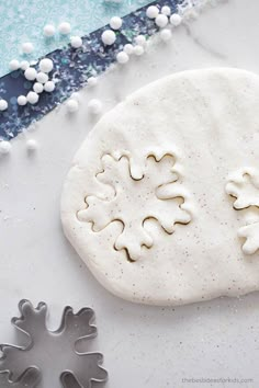 a cookie with white frosting on it next to some sugar sprinkles