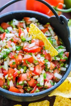 a black bowl filled with salsa and tortilla chips on top of a table