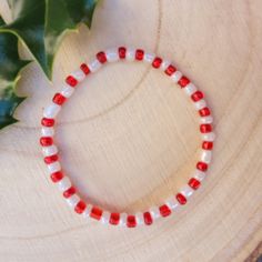 Stunning red and white candy cane design beaded Christmas bracelet. Festive White Beaded Bracelets, White Letter Beads Bracelets For Holidays, Festive White Beaded Bracelets With Colorful Beads, Adjustable White Stretch Bracelet For Holidays, Holiday Red Beaded Bracelets With Round Beads, Red Beaded Bracelets With Round Beads For Holiday, White Beaded Bracelets With Letter Beads For Christmas, Red Beaded Bracelets For Holidays, White Bracelets With Colorful Beads For Christmas